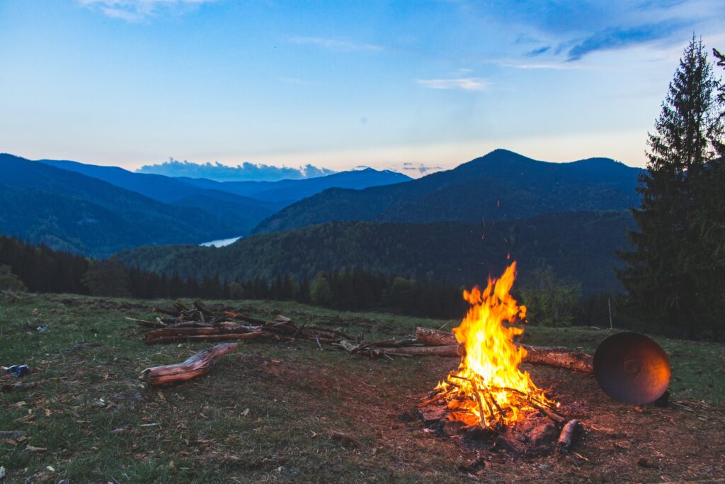 A campfire burning brightly in the mountains, symbolizing the spark of inspiration and personal growth.